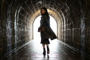 Base Setup

keep 100 percent facial information adherence of the attached image and turn her into a fashion model walking through a dim stone tunnel toward a bright exit, captured as a live action photograph or movie still, not an illustration or CGI render. Her styling leans seductive and attractive through fashion, attitude, and mood rather than explicit content.

Shot and Camera

Full body silhouette shot from behind at slightly low camera height, matching the original perspective and narrow tunnel framing. Keep her stride, tunnel curvature, and vanishing light exactly as seen.

Identity and Pose

Preserve her height impression, slim silhouette, hair length, and body proportions. She walks forward with one hip subtly angled, natural arm swing, confident stride, and a slow, sensual rhythm. Her head tilts slightly as if aware of being watched. Include 8k Photorealistic and hyper realistic.

Lighting and Environment

Strong backlight from the tunnel exit creates a glowing rim around her body, with soft, scattered reflections on the wet stone floor. The tunnel remains dark with textured stone irregularities and real moisture streaks. Add subtle haze for realism and keep the environment grounded with accurate shadows and surface wear.

Masking and Constraints

Change only the outfit and styling, keep lighting, perspective, white balance, pose, face geometry, body proportions, and silhouette the same. Absolutely no added text, no cartoon look, no CGI sheen, no plastic skin, no floating feet, and no overly clean backgrounds. Maintain consistent perspective, grounded contact shadows, film like grain, and full live action realism.